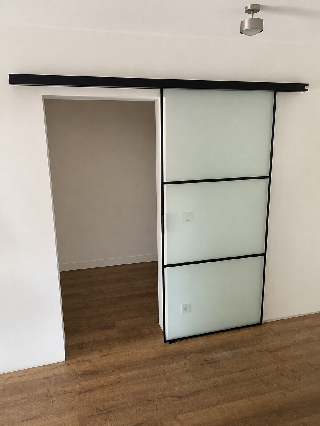 Schiebetür mit satiniertem Glas und schwarzem Rahmen